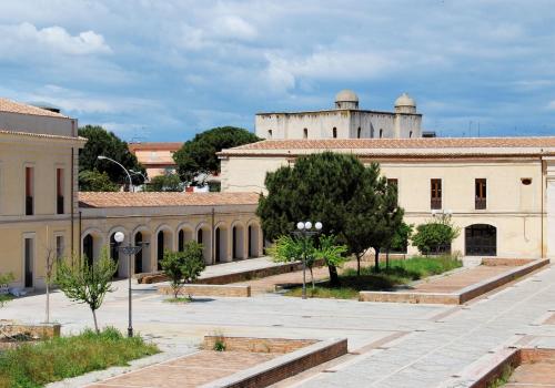 a group of buildings with a castle in the background at B&B Altamarea in Marina di Schiavonea