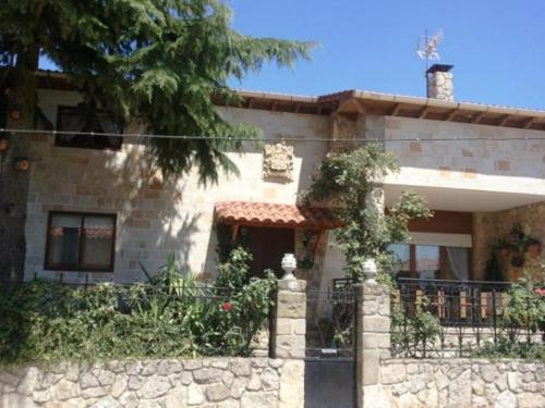 a large stone house with a fence in front of it at Casa Rural el Cedro in Abejar