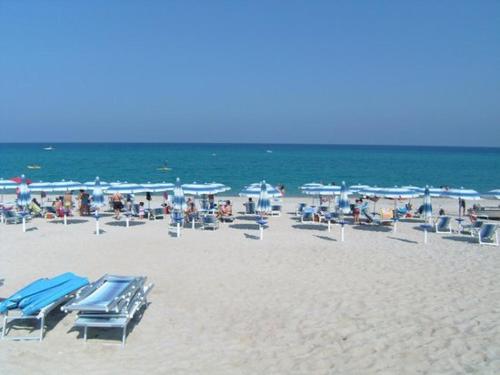 a beach with a lot of chairs and umbrellas at Villa Panorama in Zambrone