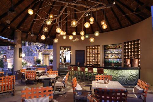 um restaurante com mesas, cadeiras e um bar em Esperanza, Auberge Collection em Cabo San Lucas