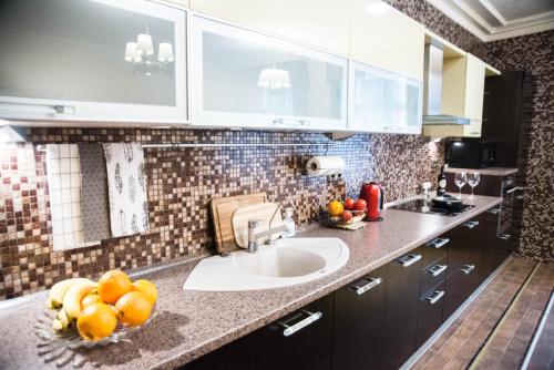 a kitchen with a sink and some fruit on a counter at Riga Center Old Town Apartment in Rīga