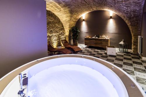 a bath tub in a bathroom with a brick wall at Marie Claire Apartments & Spa in Vasto