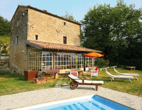 a house with a swimming pool in front of a building at b&b LATORDICELLA in Castel del Rio