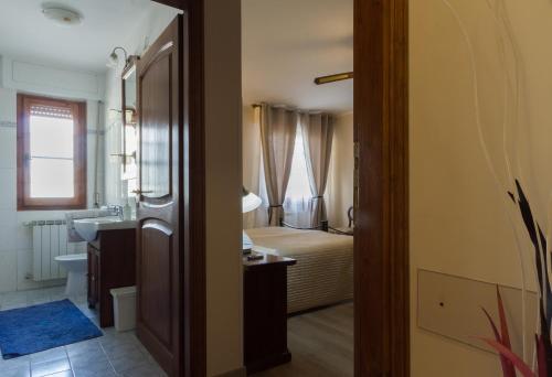 1 dormitorio con 1 cama y baño con lavabo. en La Bella Casa del Cuoco, en Campi Bisenzio