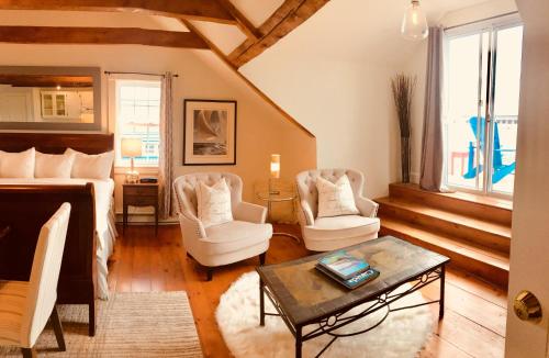 a bedroom with a bed and two chairs and a table at Treadwell Inn in Saint Andrews