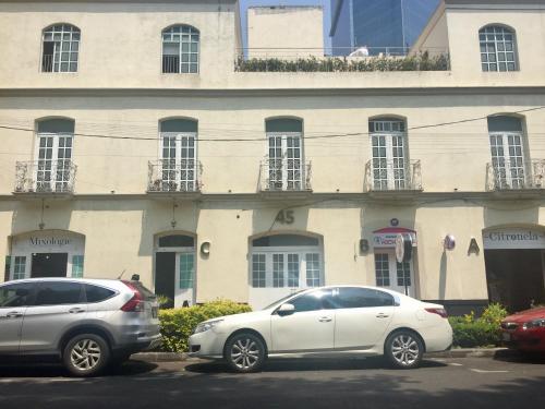 two cars parked in a parking lot in front of a building at Suites Hamburgo in Mexico City