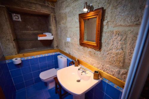 a bathroom with a sink and a toilet and a mirror at As Chivas in Redondela