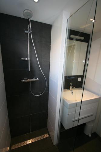 a bathroom with a shower and a sink at Bungalow Schotvanger in Egmond aan den Hoef