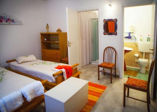 a bedroom with two beds and a bathroom at casa padre Jerone in Gangi