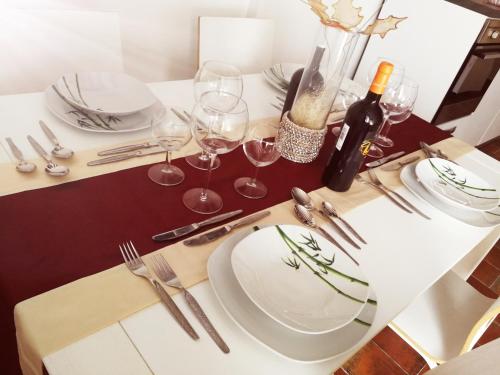 a table with a white plate and wine glasses at Casa Elia in Venice