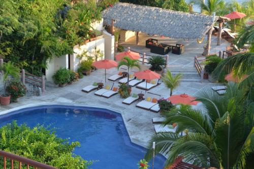 an overhead view of a pool with chairs and umbrellas at Hotel Aura del Mar in Zihuatanejo