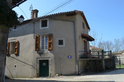 une maison ancienne avec une porte verte dans une rue dans l'établissement Saint Paul des Fonts, à Saint-Paul-des-Fonts