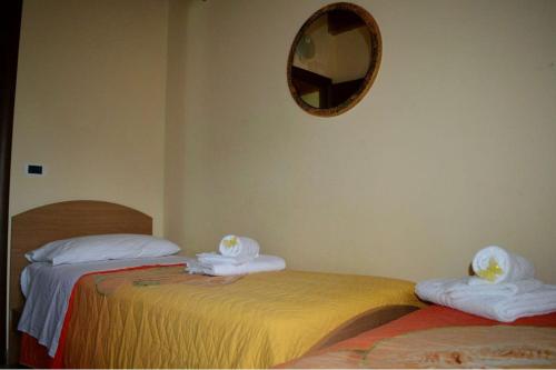 two beds in a room with a mirror on the wall at Villa Panorama in Zambrone