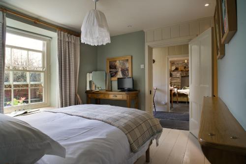 1 dormitorio con cama, escritorio y ventana en Nantgwynfaen Organic Farm Wales, en Llandysul