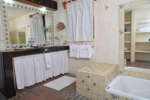 a bathroom with white towels and a sink and a tub at Hotel Aura del Mar in Zihuatanejo