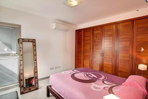 a bedroom with a pink bed and a mirror at Villa Cristal in Tijarafe