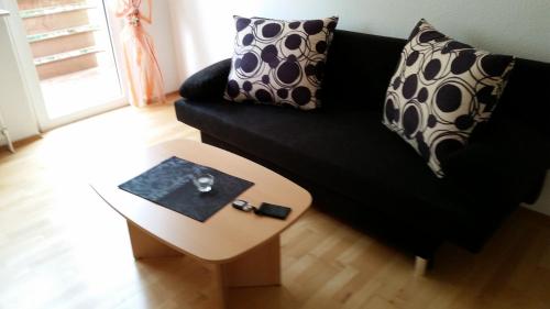 a living room with a black couch and a table at Altstadtperle in Emden