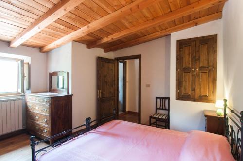 - une chambre avec un lit et un plafond en bois dans l'établissement Country House Vezzano, à Chiusi della Verna