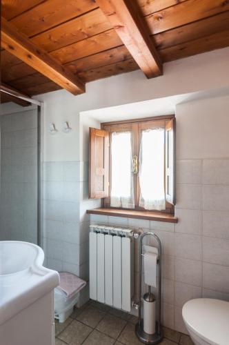 a bathroom with a toilet and a window at Country House Vezzano in Chiusi della Verna