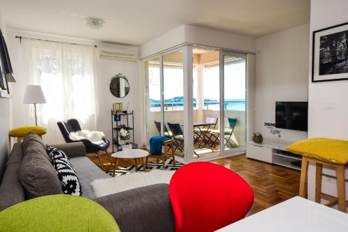 a living room with a couch and a television and a table at A&M Cavtat, sunset 3 bedrooms apartment with parking in Cavtat