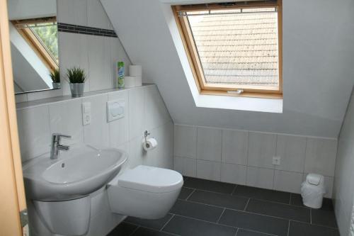 a white bathroom with a sink and a toilet at Ferienhaus im Nürburgring in Herschbroich