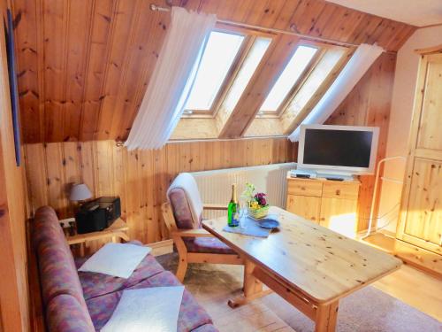 a living room with a table and a tv at Haus-Scheel-2 in Burg auf Fehmarn