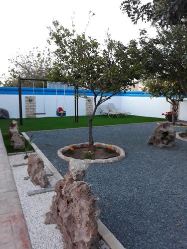 a tree in a park with rocks around it at Kalli Villa in Pomos