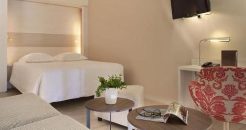 a hotel room with a bed and a couch and a table at Oceania Clermont Ferrand in Clermont-Ferrand