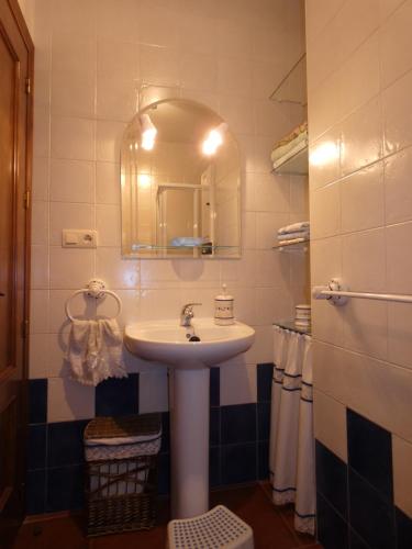 a bathroom with a sink and a mirror and towels at Casa El Paseo in Arriate