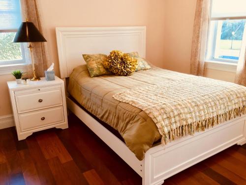 a bedroom with a bed and a night stand with a lamp at Avalon Beach in Fort Pierce