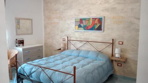 una camera da letto con un letto e un dipinto sul muro di Casa Vacanza Orizzonte a Marina di Camerota