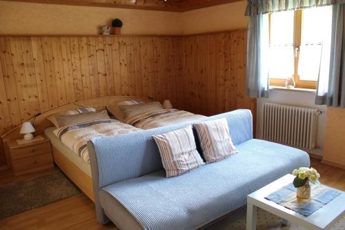 アルンブルックにあるFerienwohnung Hausladenのベッドルーム1室(ベッド1台、ソファ、窓付)