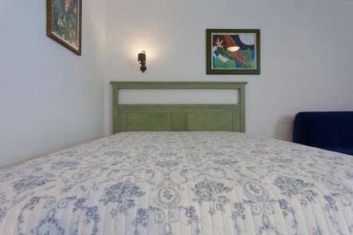 a bedroom with a bed with a blue and white bedspread at Krk Houses in Kornić