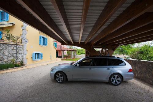 a small silver car parked under a building at Krk Houses in Kornić