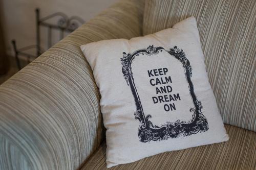 a pillow sitting on a couch with a keep calm and dream on at Krk Houses in Kornić