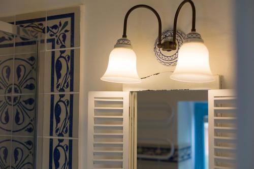 two lights are hanging above a mirror in a bathroom at Krk Houses in Kornić