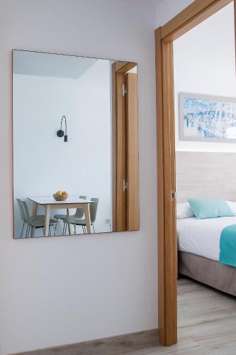 a bedroom with a mirror and a bed and a table at Aparthotel Cye Holiday Centre in Salou