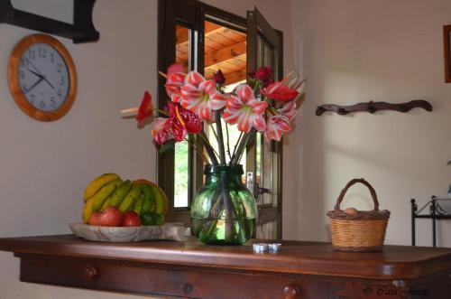 a table with a vase with flowers and fruit on it at Casa Jonay in Hermigua