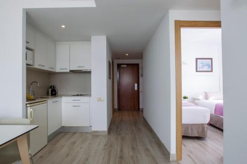 a kitchen and a bedroom with a bed in a room at Aparthotel Cye Holiday Centre in Salou