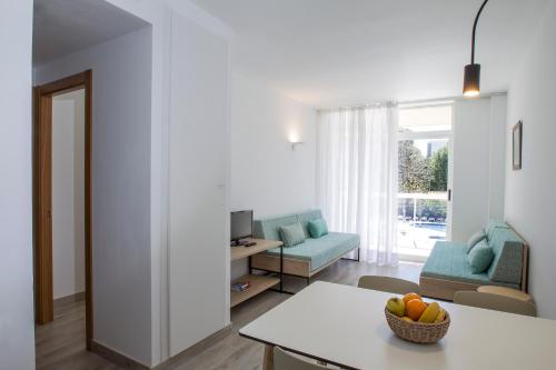 a living room with a table with a bowl of fruit at Aparthotel Cye Holiday Centre in Salou