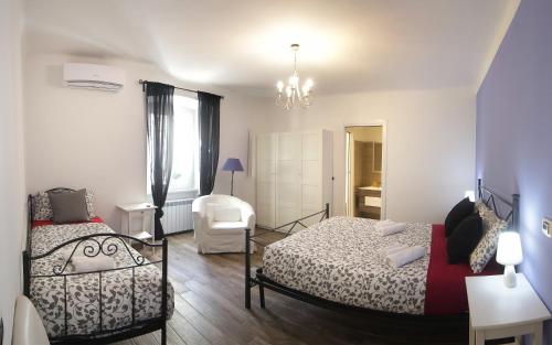 Un dormitorio con 2 camas y una silla. en Vento d'Estate, en Trieste
