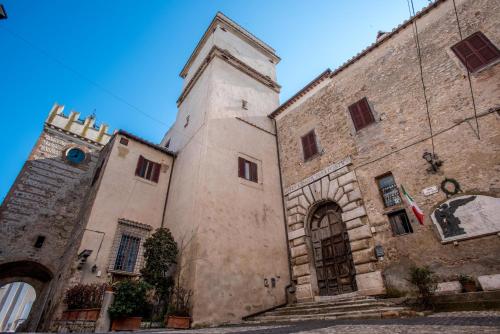 an old building with a tower and a clock at Luxury Relais Cuore Sabino in Stimigliano