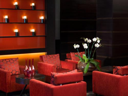 a room with red chairs and a table and a vase of flowers at Dan Panorama Jerusalem Hotel in Jerusalem