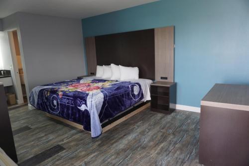 Schlafzimmer mit einem Bett mit blauer Wand in der Unterkunft Thunderbird Motel in Bishop