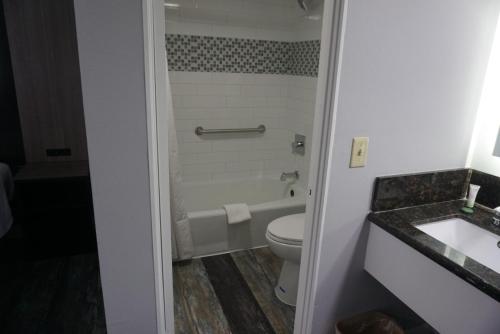 a bathroom with a toilet and a tub and a sink at Thunderbird Motel in Bishop