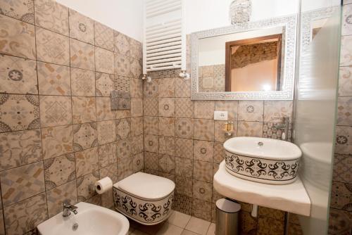 a bathroom with a sink and a toilet and a mirror at Luxury Relais Cuore Sabino in Stimigliano