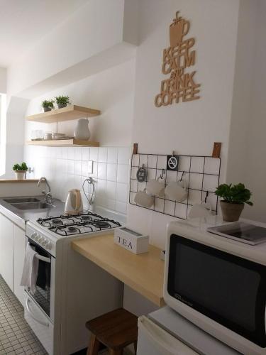 a kitchen with a stove and a tv in it at Habitania Bahia - Cochera opcional in Bahía Blanca