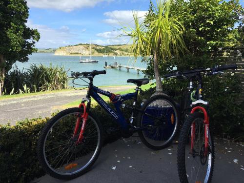 two bikes parked next to each other near the water at Beach Lane Apartment in Whangarei