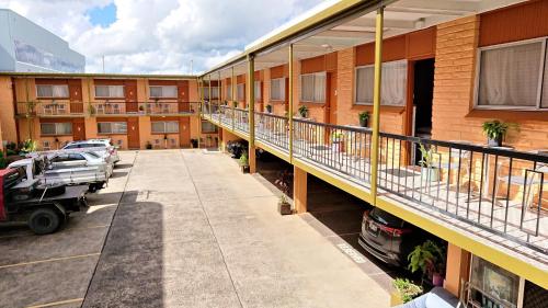 an apartment building with a balcony and a parking lot at New Olympic Motel in Lismore