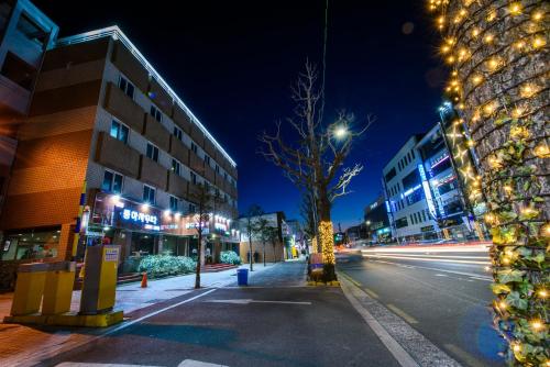 an empty city street at night with christmas lights at Gangneung Donga Hotel in Gangneung